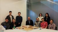 Alumni and students gathered together in a school classroom.